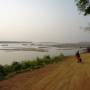 Cambodge - Bords du Mekong. Nous sommes à la fin de la période sèche, ce gigantesque fleuve est donc en partie asséché et laisse apparaitre quelques bancs de sables. Au loin, vous pouvez apercevoir quelques maison flottantes où logent des familles vietnamiennes. Kra