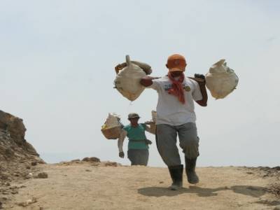 les ouvriers sur le chemin de terre descendent leurs 80kg de souffre en balancier sur leur épaules