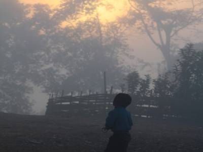 Un enfant chassant les oiseaux au lance-pierre au petit matin