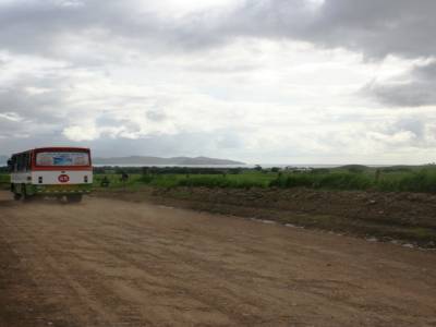 Un bus, toujours accompagne de son nuage de poussiere